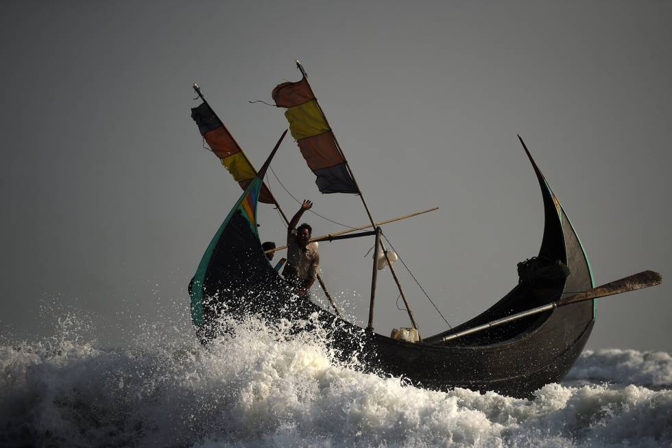 Pie de Foto: Los refugiados rohingya tripulan un barco pesquero desde la playa de Shamlapur en dirección a la Bahía de Bengala, cerca de Cox's Bazar (Bangladesh)