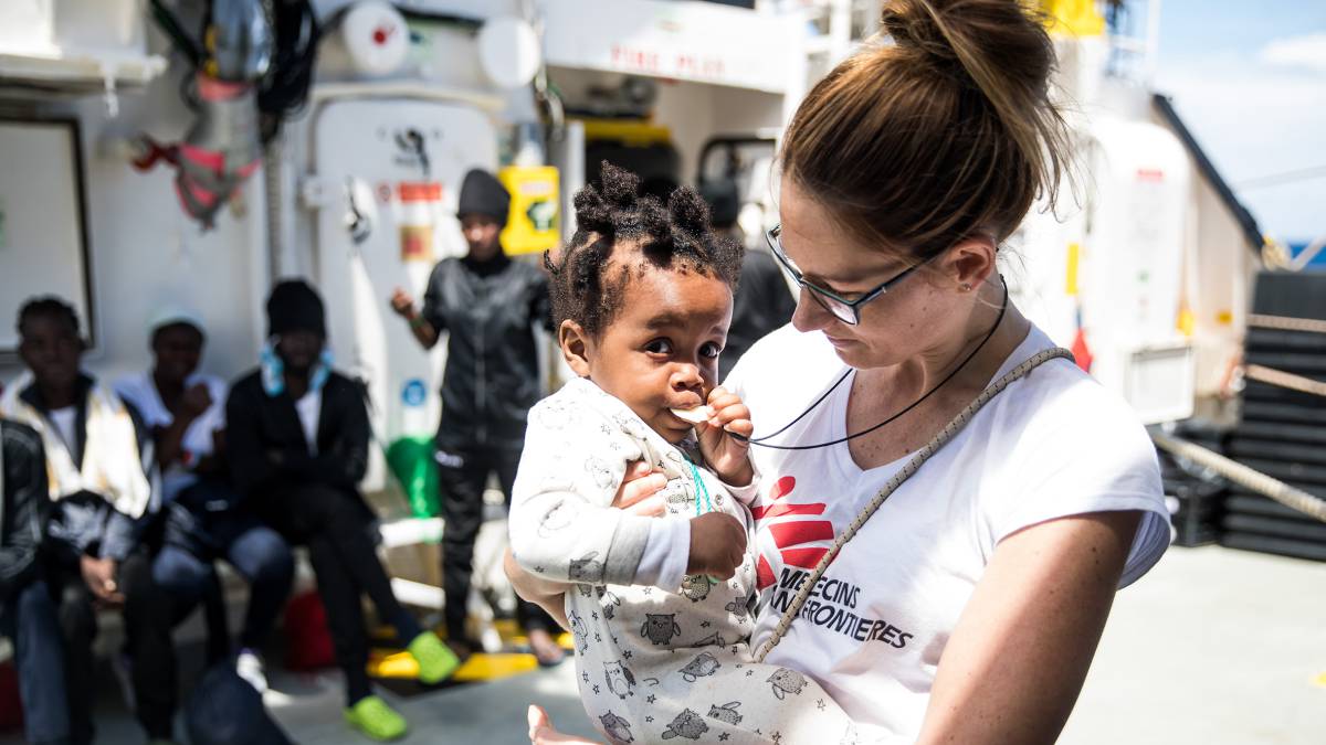 Un bebé rescatado de una de las pateras en brazos de una trabajadora de MSF a bordo del 'Aquarius', el 14 de junio de 2018.