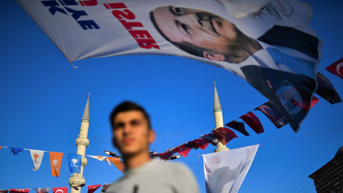Un joven pasa bajo un cartel electoral de Erdogan.