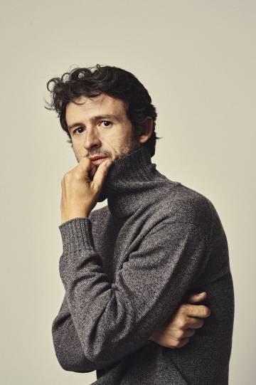 Diego Martín posa para ICON con jersey gris de cuello alto de Mirto y esa cara de bueno que le hace perfecto para hacer de villano.