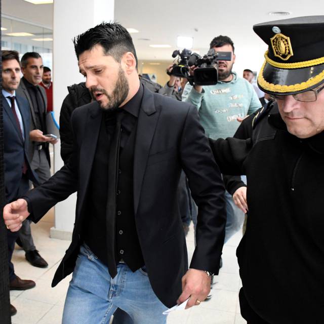 Matias Messi escoltado por un policía en los juzgados de Rosario, Argentina, este jueves.