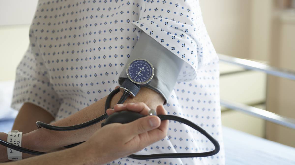 Un médico toma la tensión a un paciente.