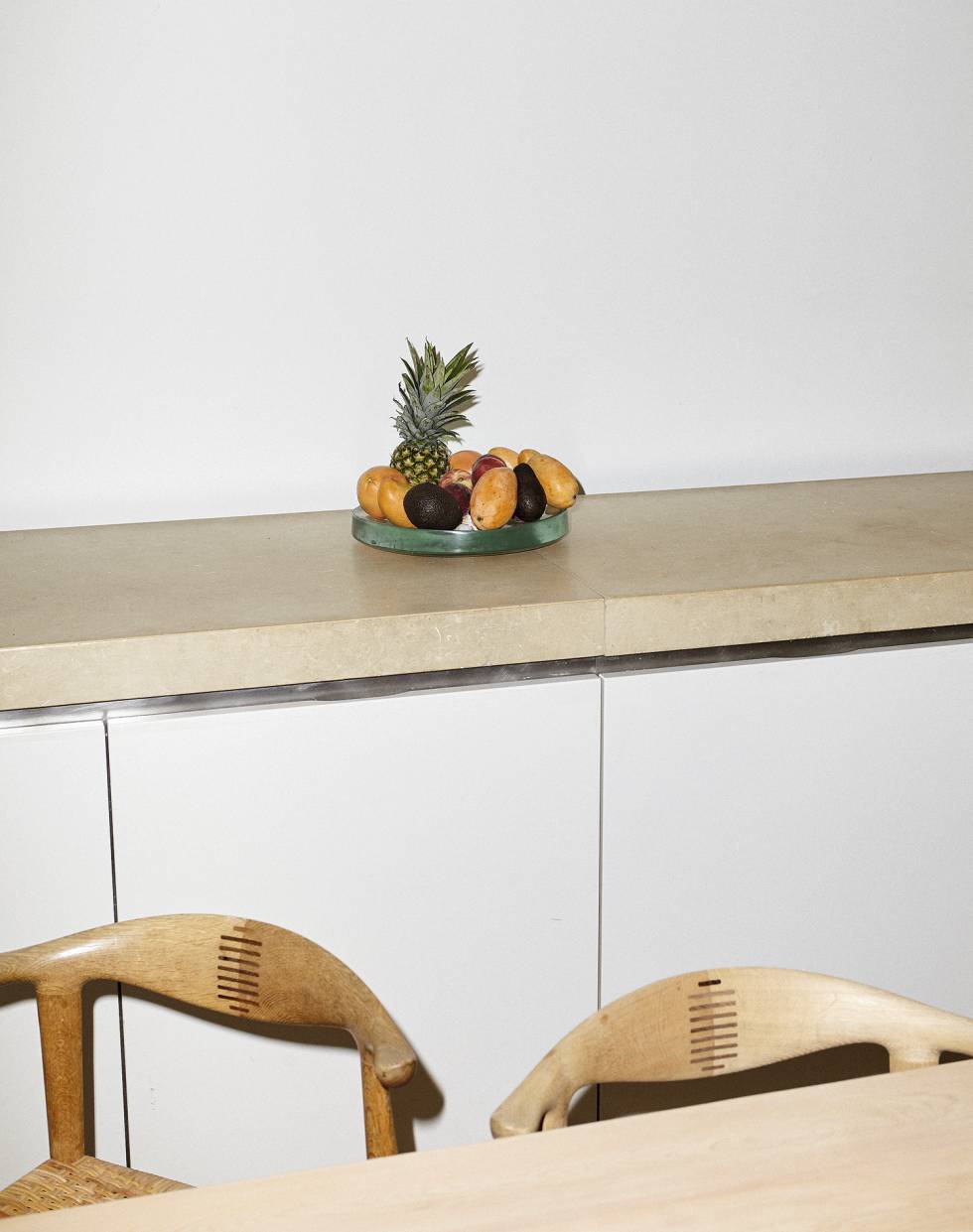 La cocina de los Pawson es un túnel con un mueble continuo a la izquierda, armarios a la derecha y una gran mesa de madera en el centro. El frutero es una concesión al colorido que logramos que el arquitecto no quitara de en medio. “No soy diseñador de producto”, dice Pawson.