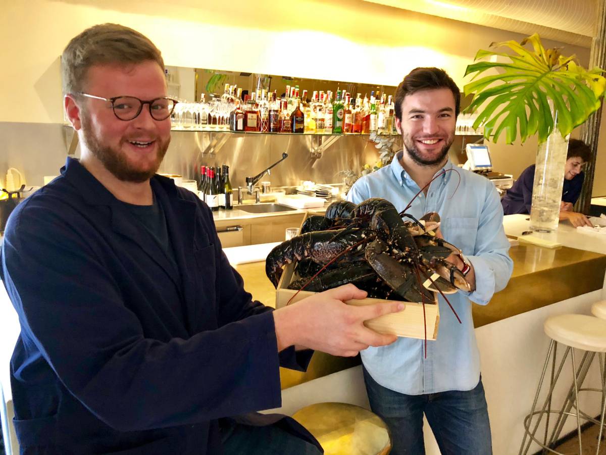 ARNAUD KERES Y CLÉMENT DE LA JONQUIERE, CON UNA BANDEJA DE BOGAVANTES, DELANTE DE LA BARRA DE LOBSTERIE CAPEL