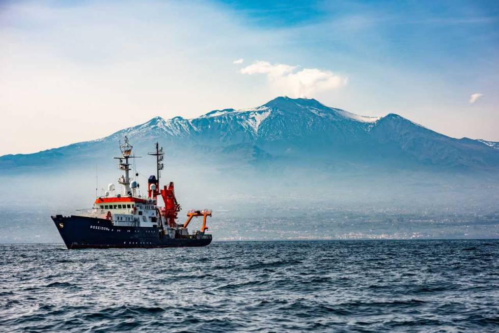 El barco usado para instalar instrumentos submarinos navega frente al Etna.