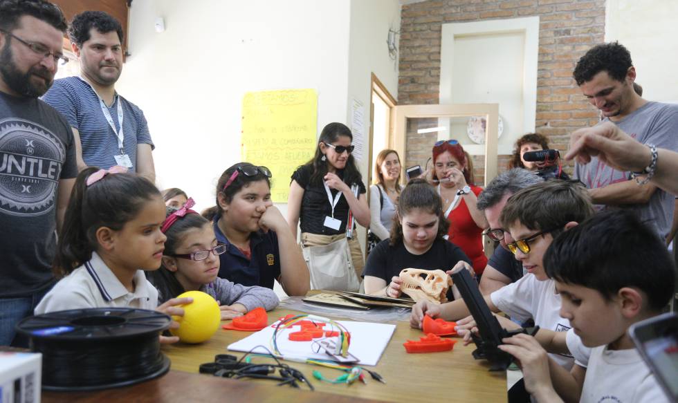 Un grupo de niños con discapcidad visual toca los objetos impresos en 3D.