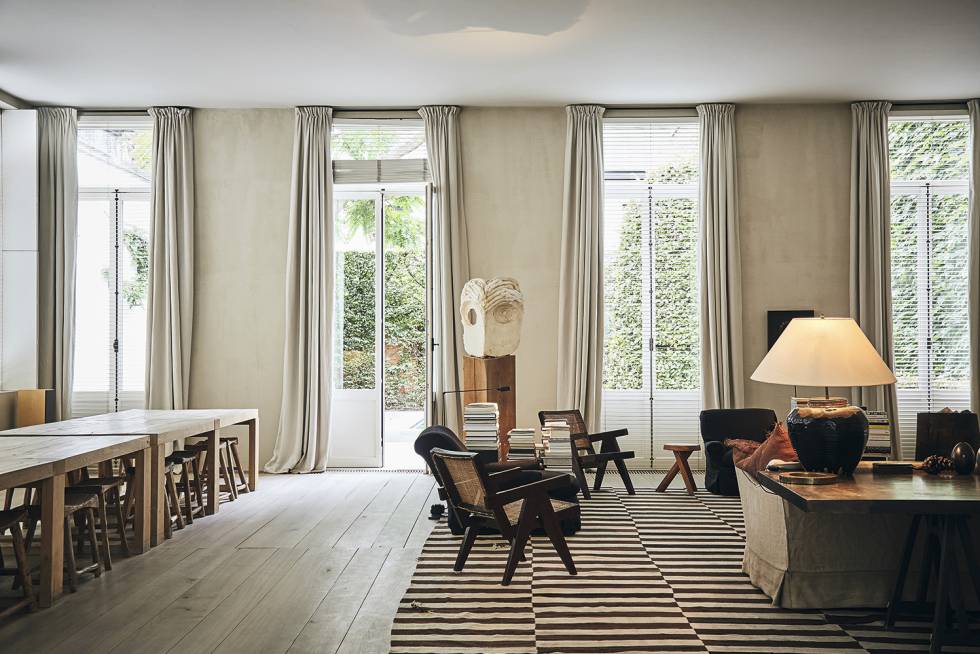 En el monumental salón con vistas al jardín, Van Duysen sustituyó las ventanas con cuarterones típicas de la zona por ventanas francesas, más sencillas. La mesa y los sofás están hechos a medida y las sillas son antigüedades chinas y piezas originales de Pierre Jeanneret.