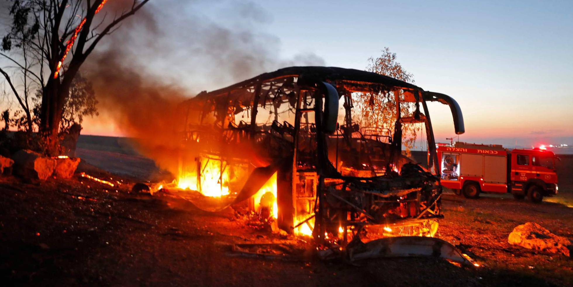 Um ônibus arde depois de ser alcançado por fogo palestino.