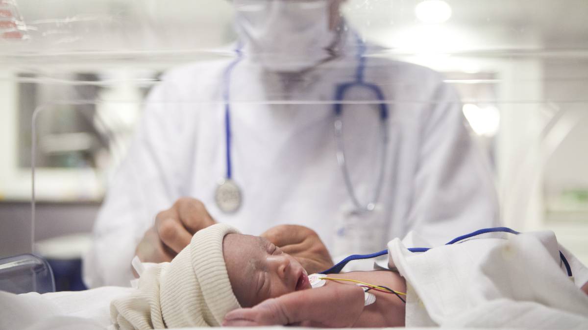 Un doctor con un bebé prematuro.