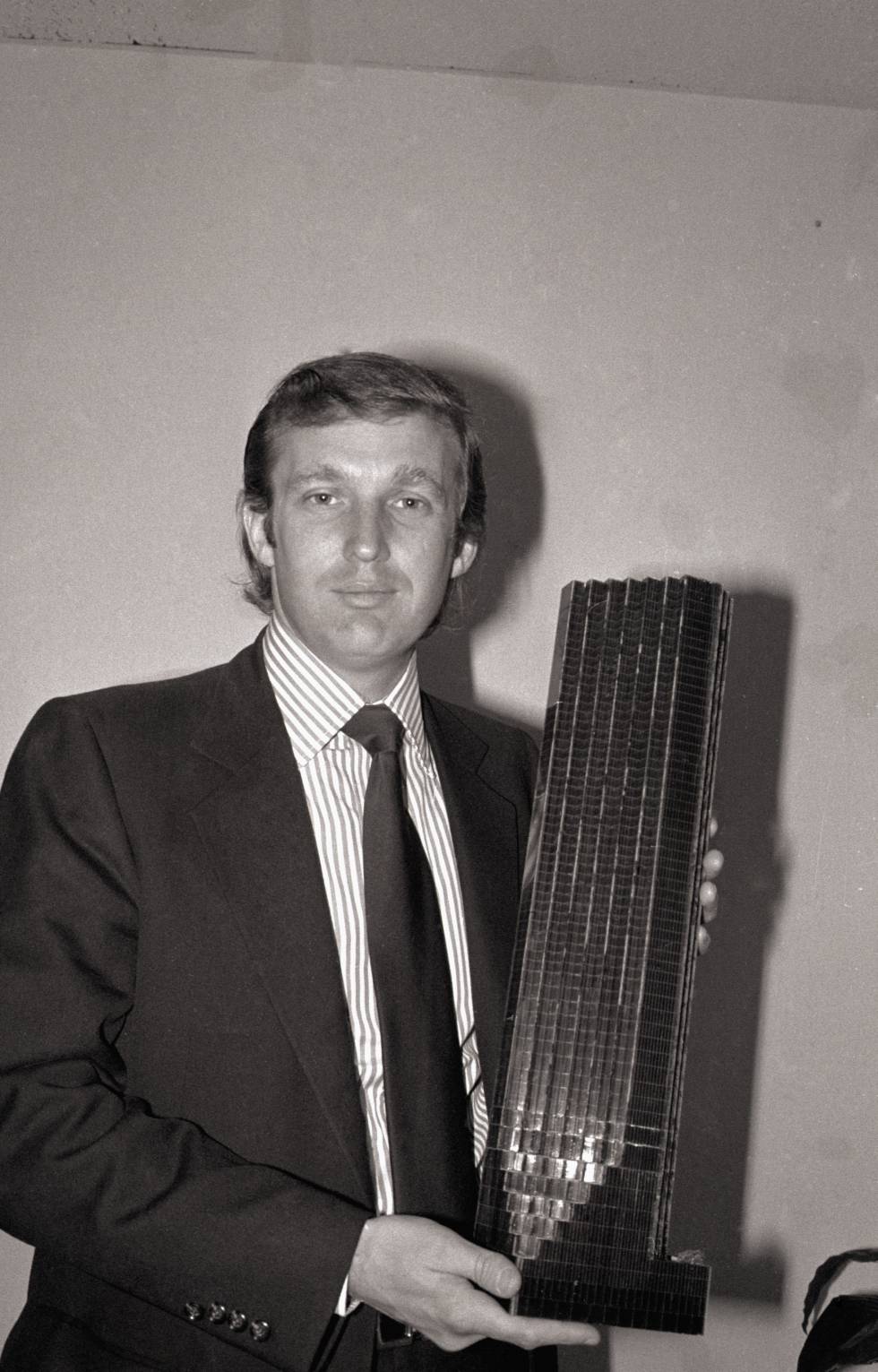 Donald Trump en 1980, con 34 años, sostiene la maqueta de lo que será el rascacielos que lleva su nombre.