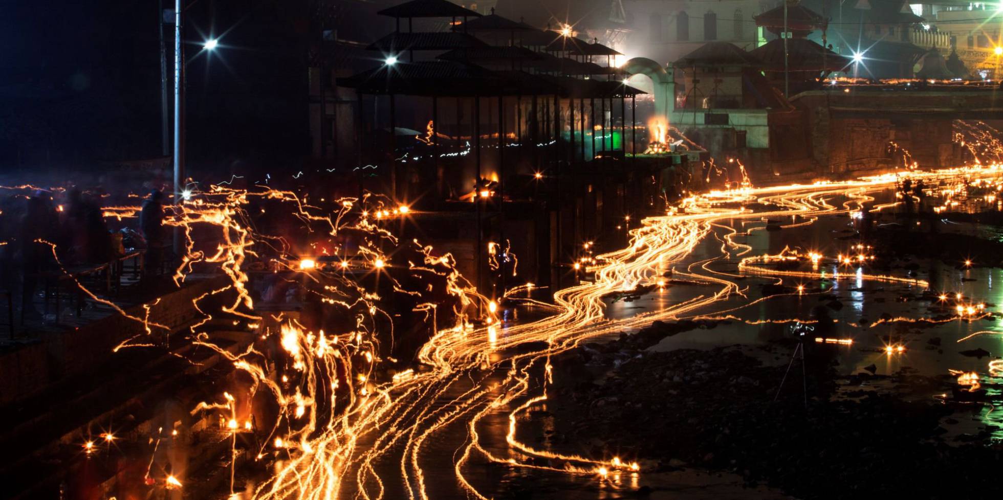 Los devotos nepaleses lanzan lámparas de aceite en memoria de miembros de la familia fallecidos durante el festival Balachaturdashi en el templo Pashupati en Katmandú (Nepal).
