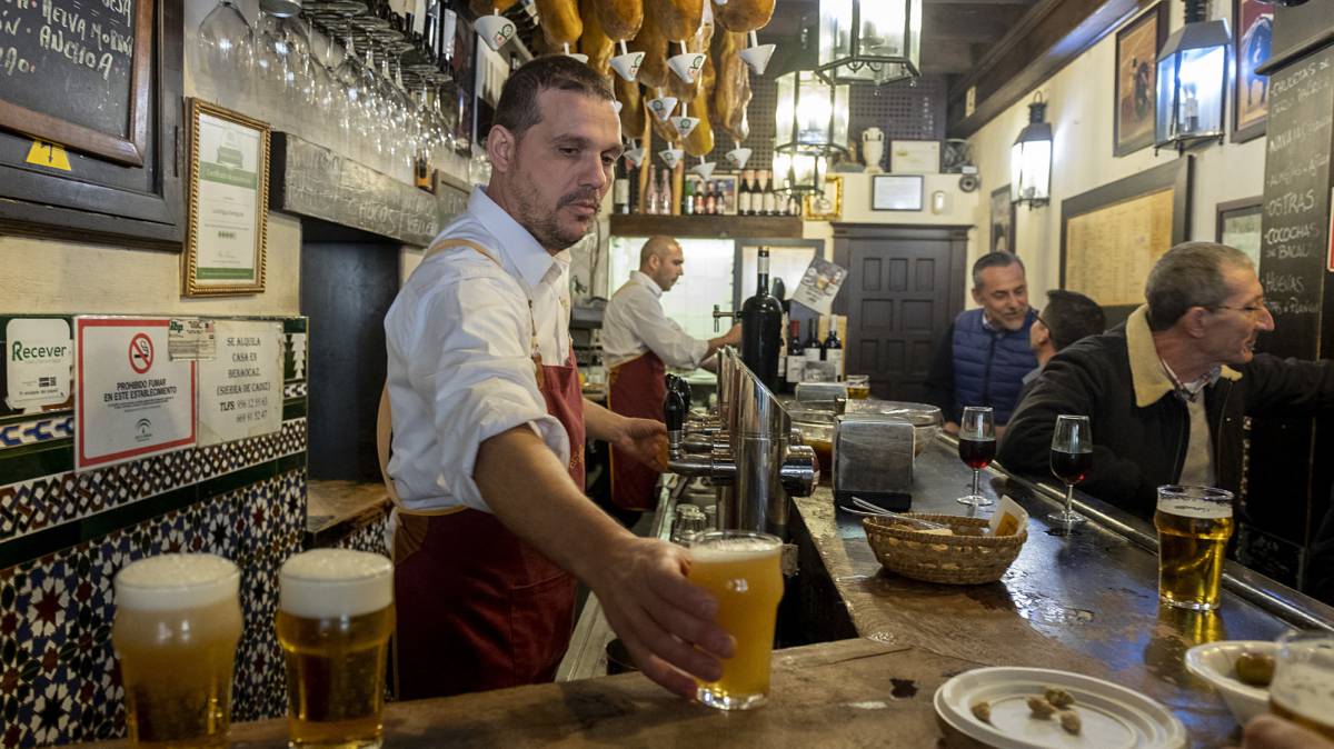 Un camarero pone cerveza en Sevilla.