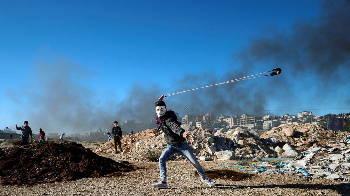 Un palestino lanza piedras con una honda.