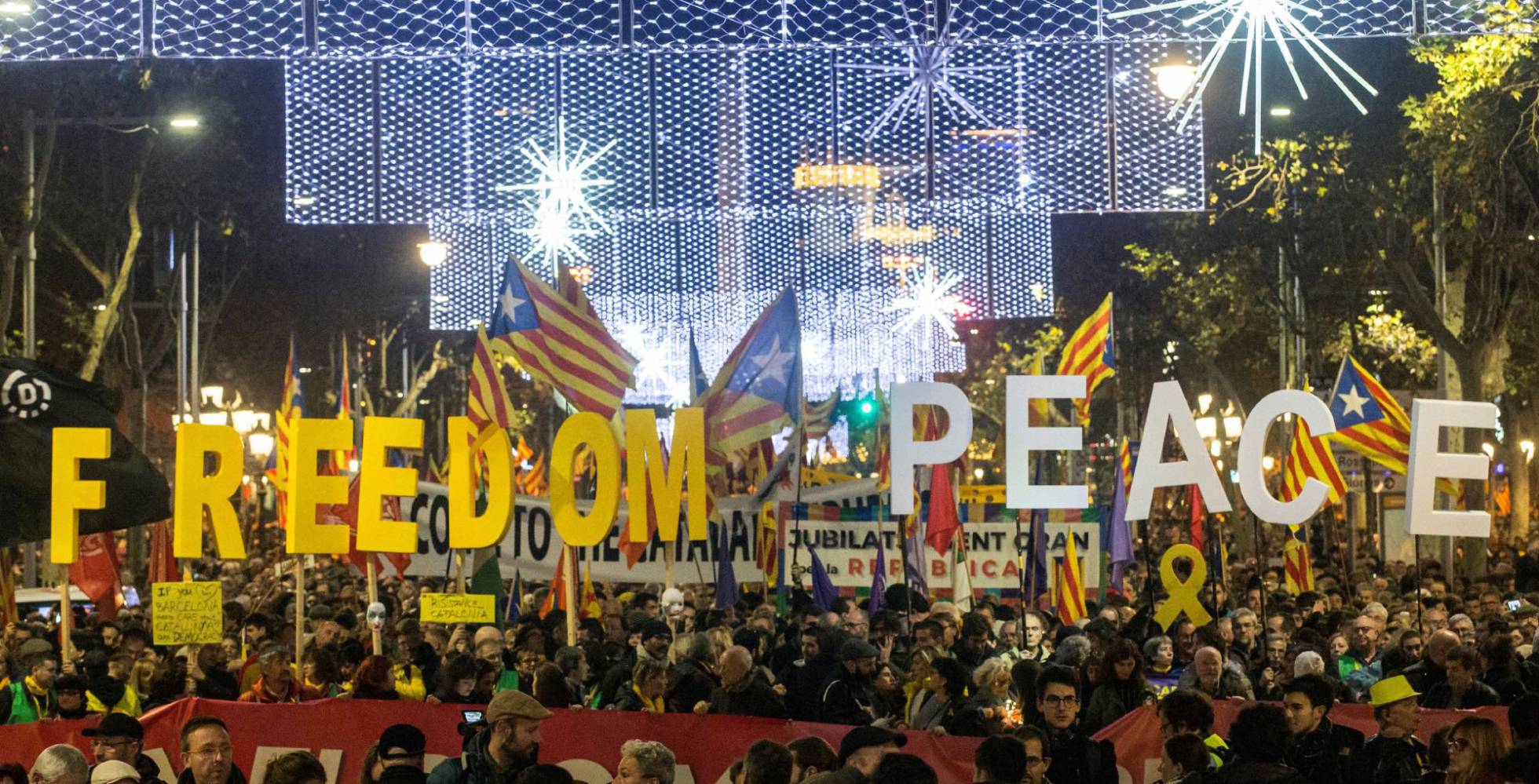 Un grupo de manifestantes sujeta pancartas en las que piden libertad y paz durante la protesta convocada por ANC contra el Consejo de Ministros celebrado este viernes en Barcelona.