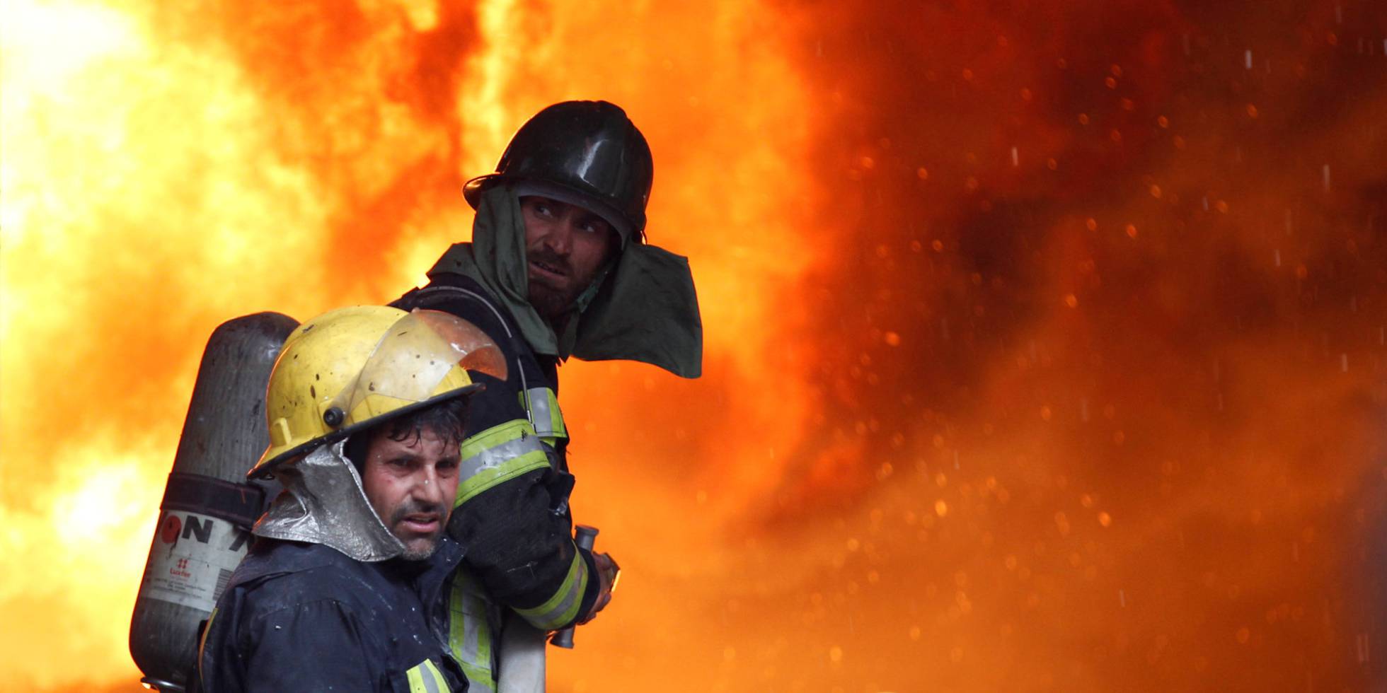 Bomberos de Afganistán combaten el fuego en un centro comercial.