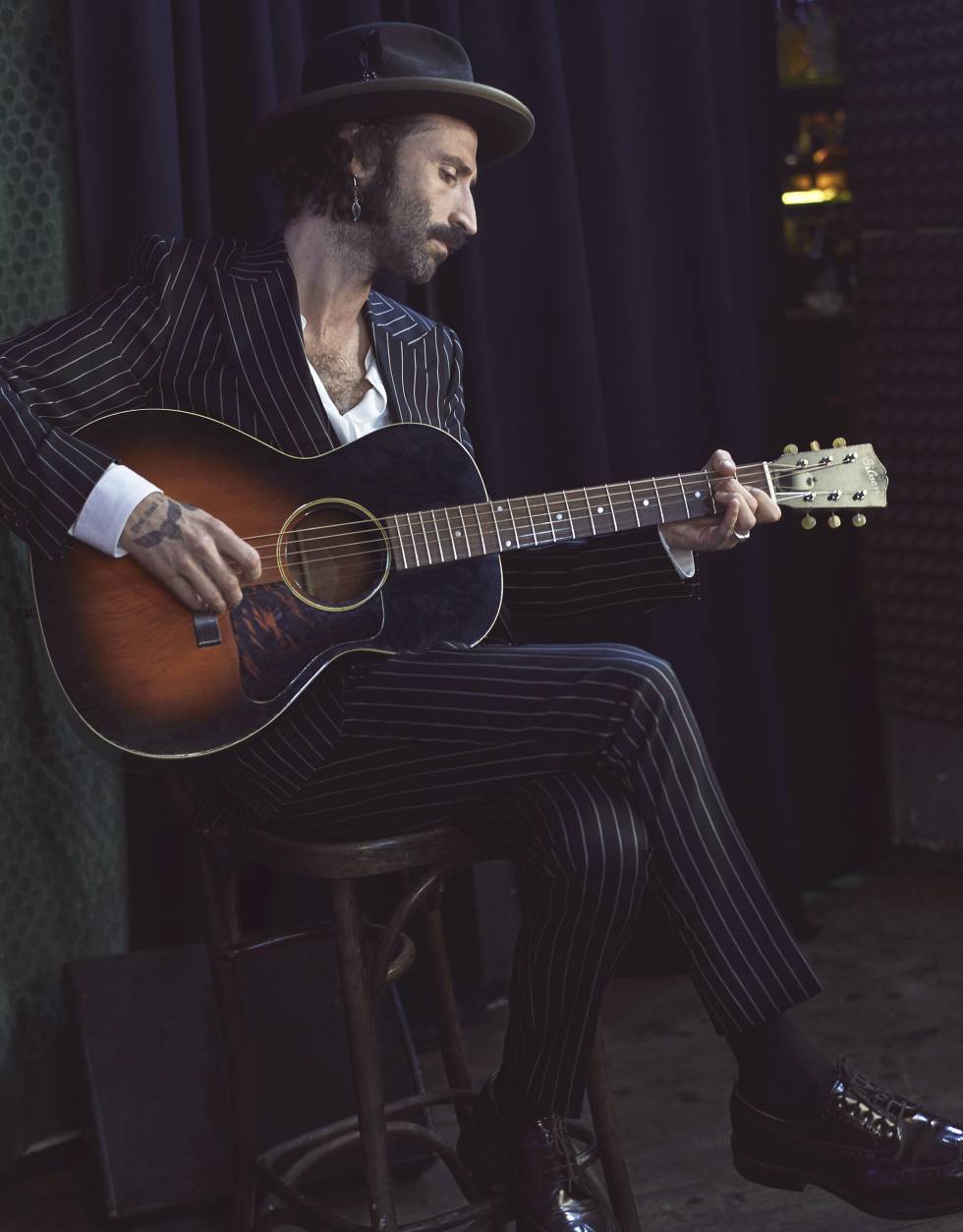 Leiva viste un traje de mil rayas de Dolce & Gabbana, camisa con cuello mao de The Kooples, zapatos de Church’s y sombrero de Sombrerería Yoqs.