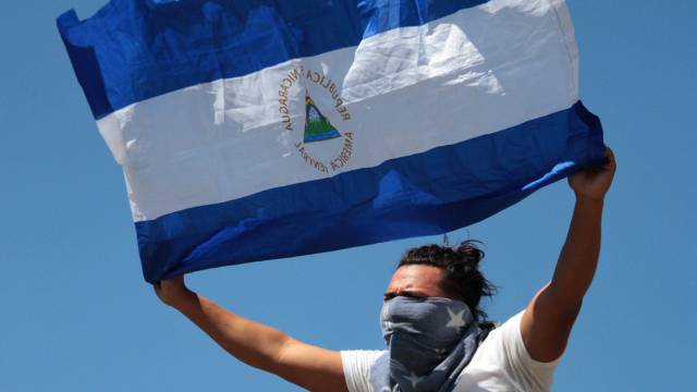Un nicaragüense hondea su bandera en Managua.