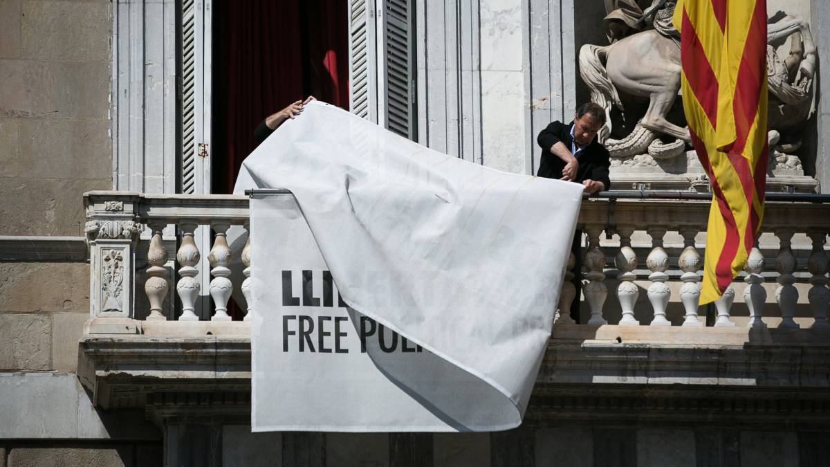 Trabajadores del Palau de la Generalitat retiran las pancartas.