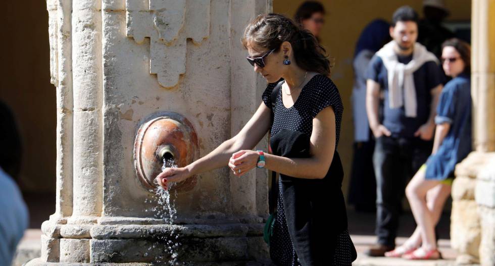 Una turista se refresca en una fuente en Córdoba.