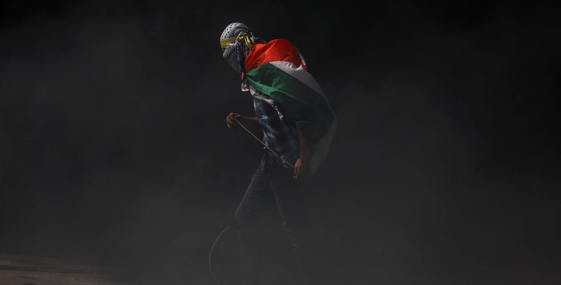 Un manifestante con la bandera de Palestina sobre sus hombros.