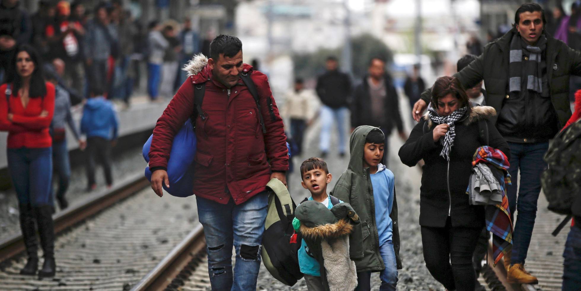 Refugiados caminan por las vía del tren durante una protesta, este viernes, en la estación central de Atenas (Grecia).
