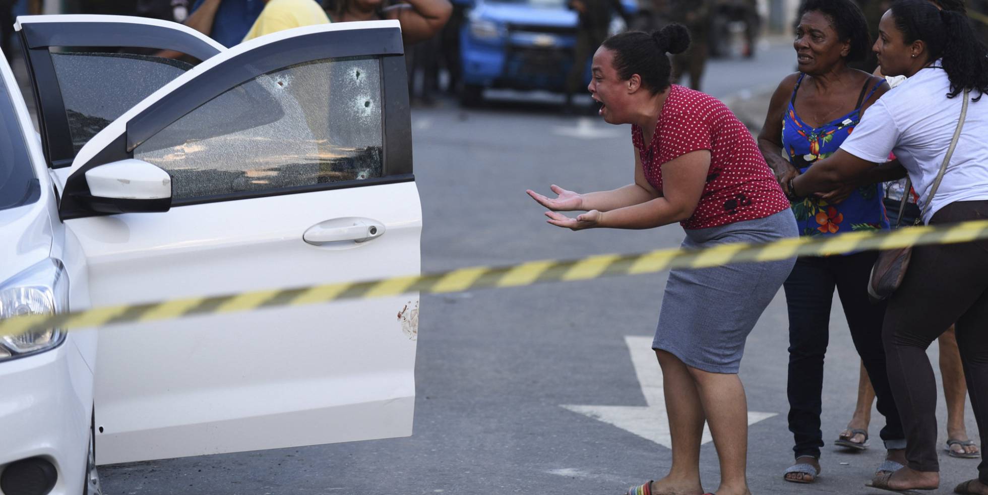 La esposa del músico Evaldo dos Santos brasileño, asesinado por las fuerzas armadas brasileñas, grita de dolor al ver el cuerpo de su esposo desplomado sobre el asiento del vehículo, en Río de Janeiro.