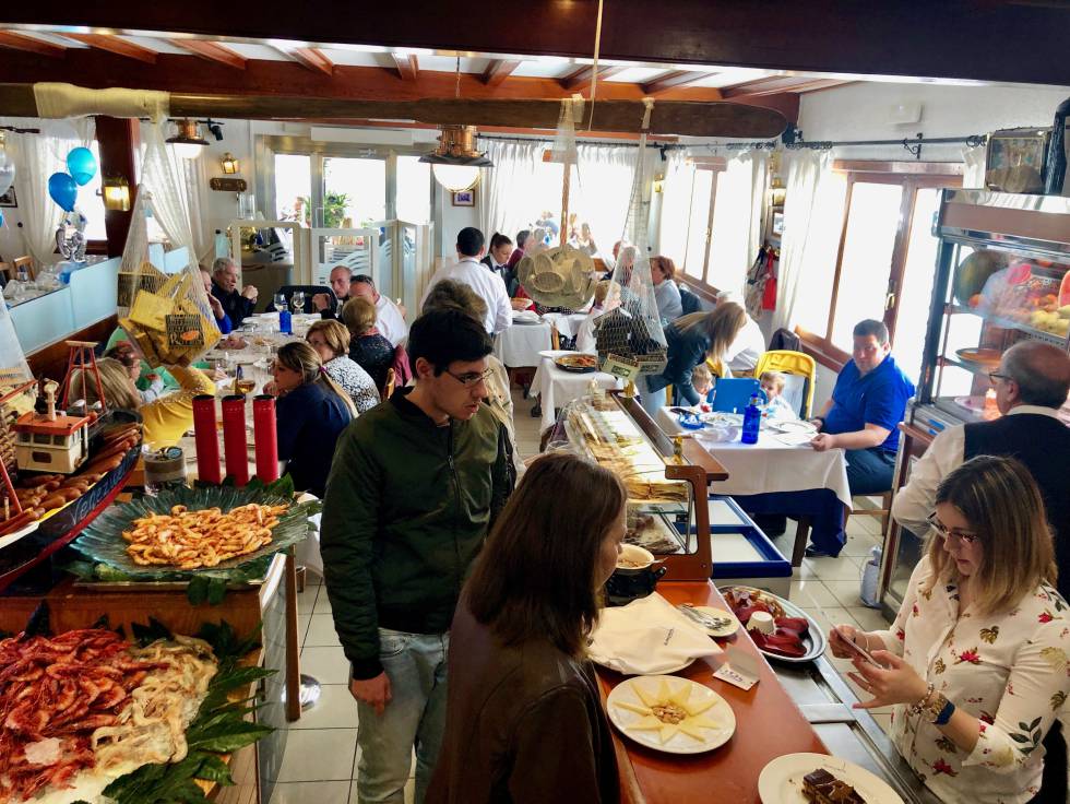 PERSPECTIVA DE UNO DE LOS COMEDORES DEL RESTAURANTE VENEZUELA CON ABUNDANTES MUESTRAS DE MARISCOS Y SALAZONES A LA VISTA CAPEL