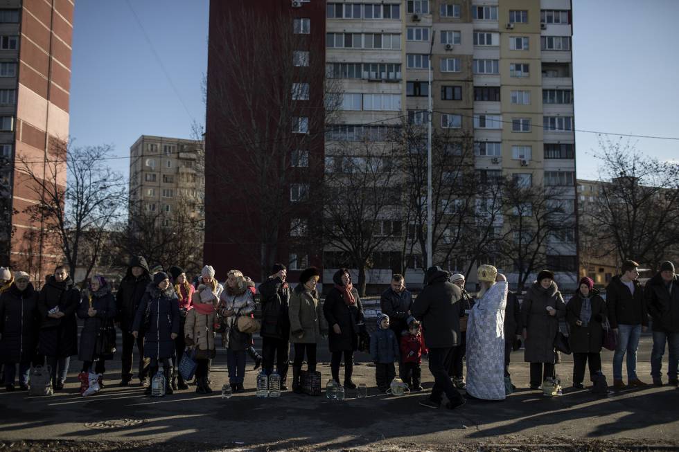 Un sacerdote de la Iglesia Ortodoxa de Ucrania de la Patriarquía de Moscú bendice agua para los vecinos del distrito de Dniprovski, en Kiev.