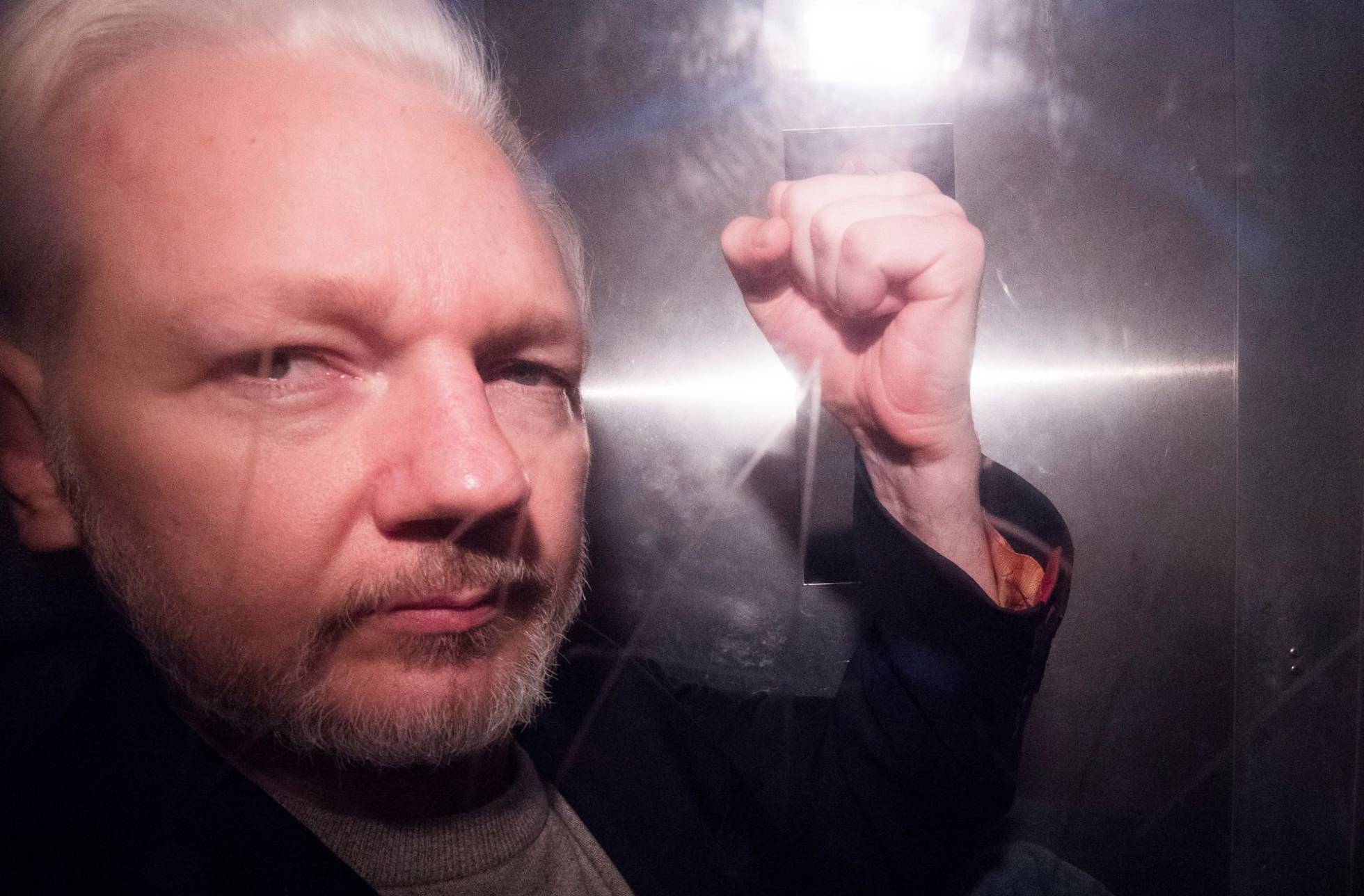 Julian Assange saluda desde un vehículo policial, en Londres.