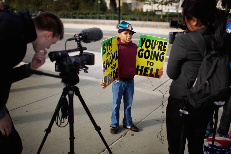 Daniel Phelps, de nueve años y uno de los muchísimos nietos de Fred Phelps, sujeta pancartas con mensajes como: