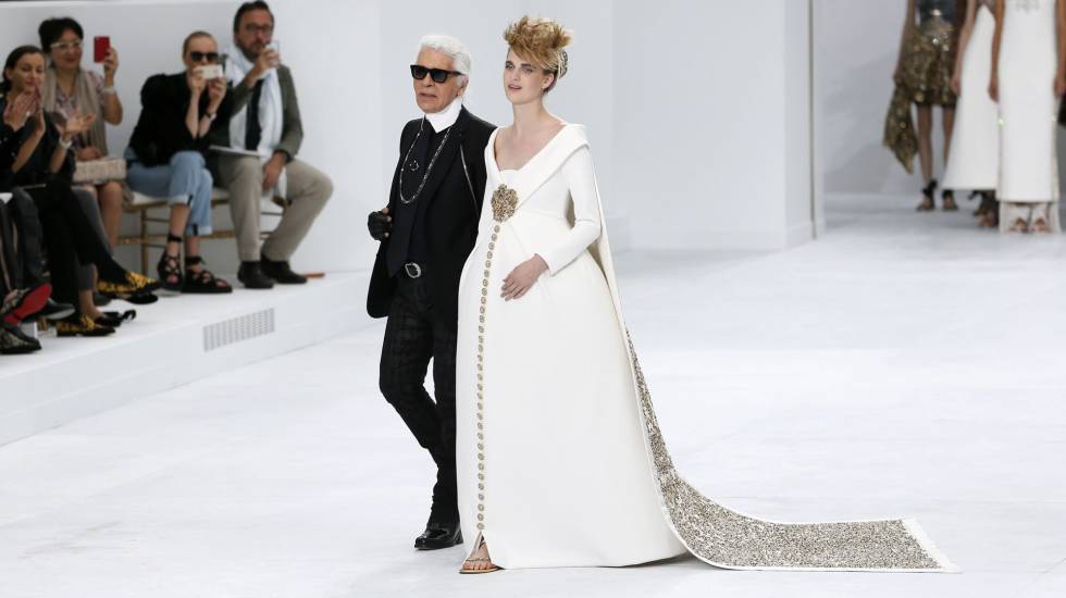 Lagerfeld, con una modelo vestida de novia al final del desfile de alta costura otoño-invierno 20142015 de Chanel, en julio de 2015