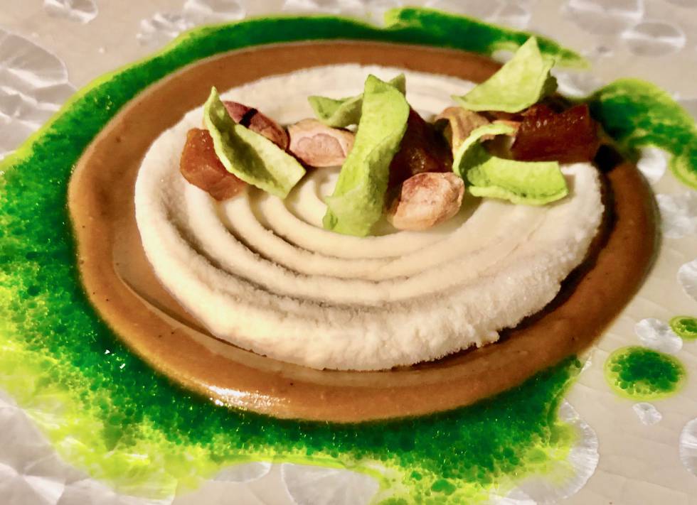 Cremas dispuestas de forma concéntrica. En el interior una pasta helada de raíz de perejil. Alrededor, crema de ajo negro fermentado con notas de café y de chocolate. A modo de aliño exterior una vinagreta de perejil Capel