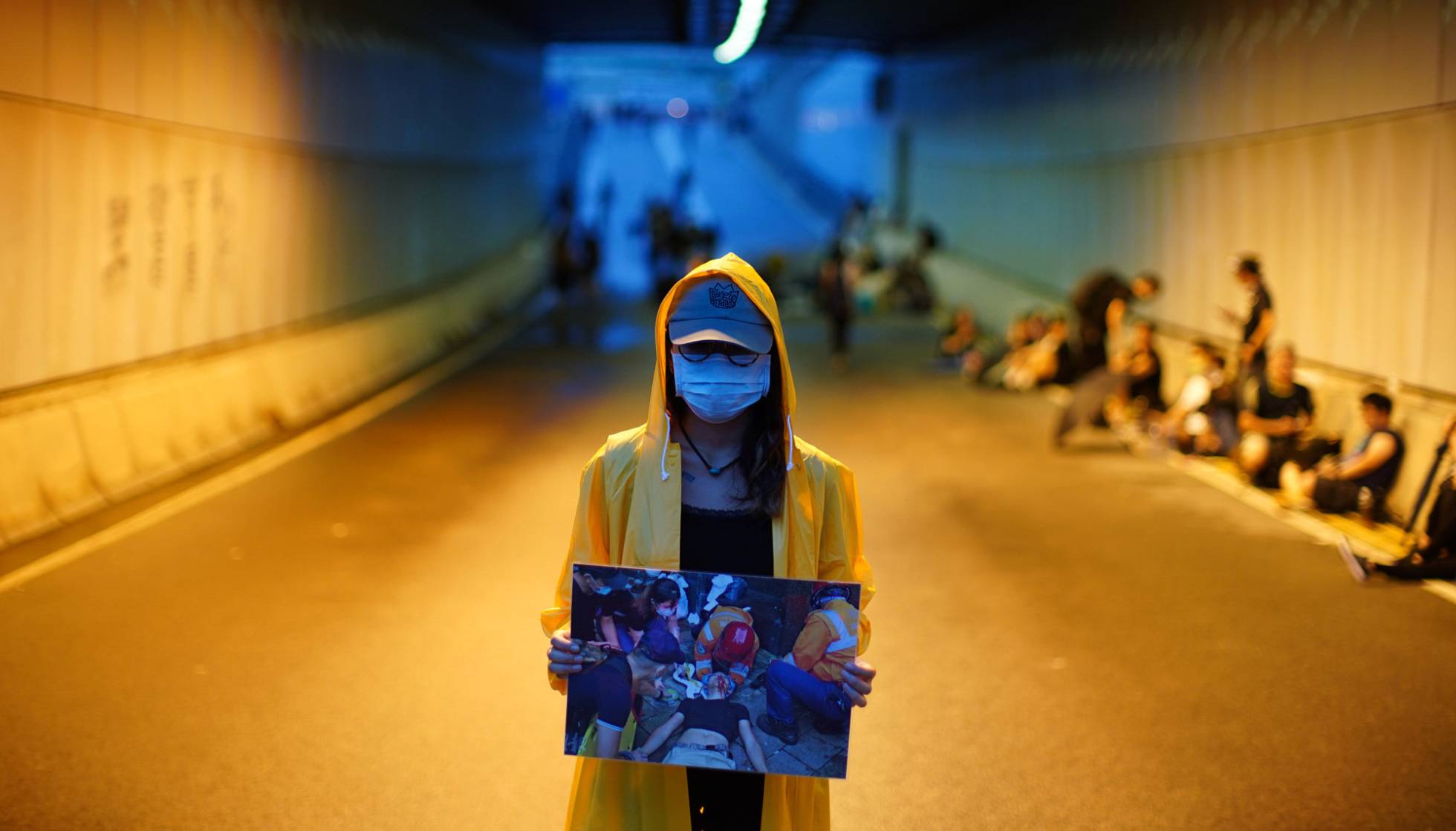 Una manifestante muestra la imagen de un herido en las protestas de Hong Kong.