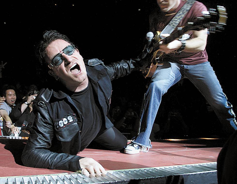 Bono, líder de U2, cantando 'End of the World' durante un concierto en 2001 con Edge a su izquierda.