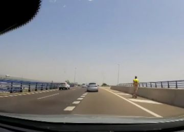 Un hombre conduce un patinete eléctrico por el arcén de una autovía