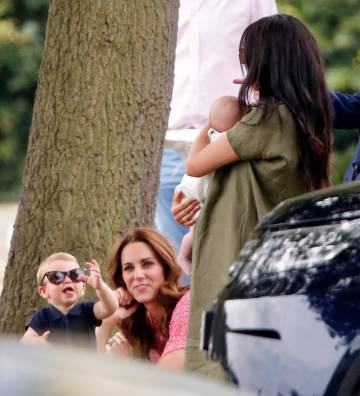 El príncipe Luis bromea mientras es observado por su madre, Kate Middleton, y Meghan Markle que tiene en brazos a Archie.
