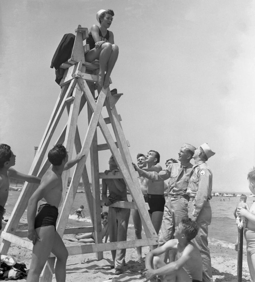 Una socorrista trabajando y muchos hombres mirando.