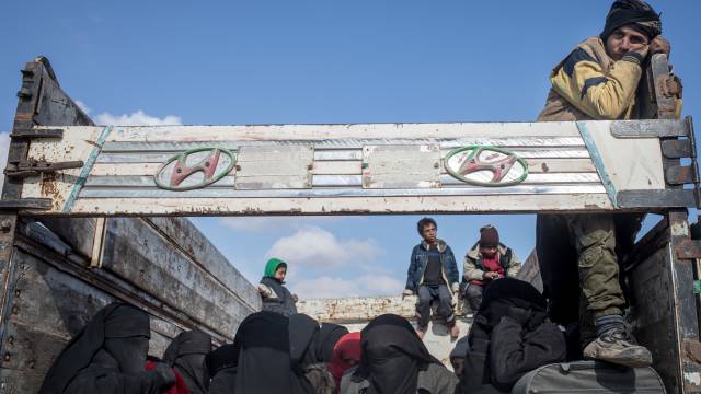 Mujeres y niños huyen de Baghouz (Siria).