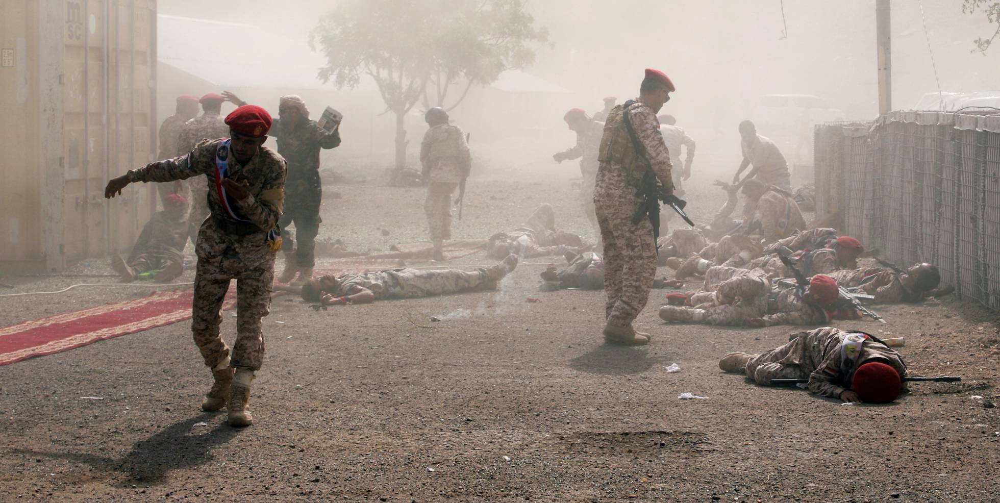 Varios soldados permanecen en el suelo tras el ataque de un misil durante un desfile militar celebrado en Aden (Yemen).