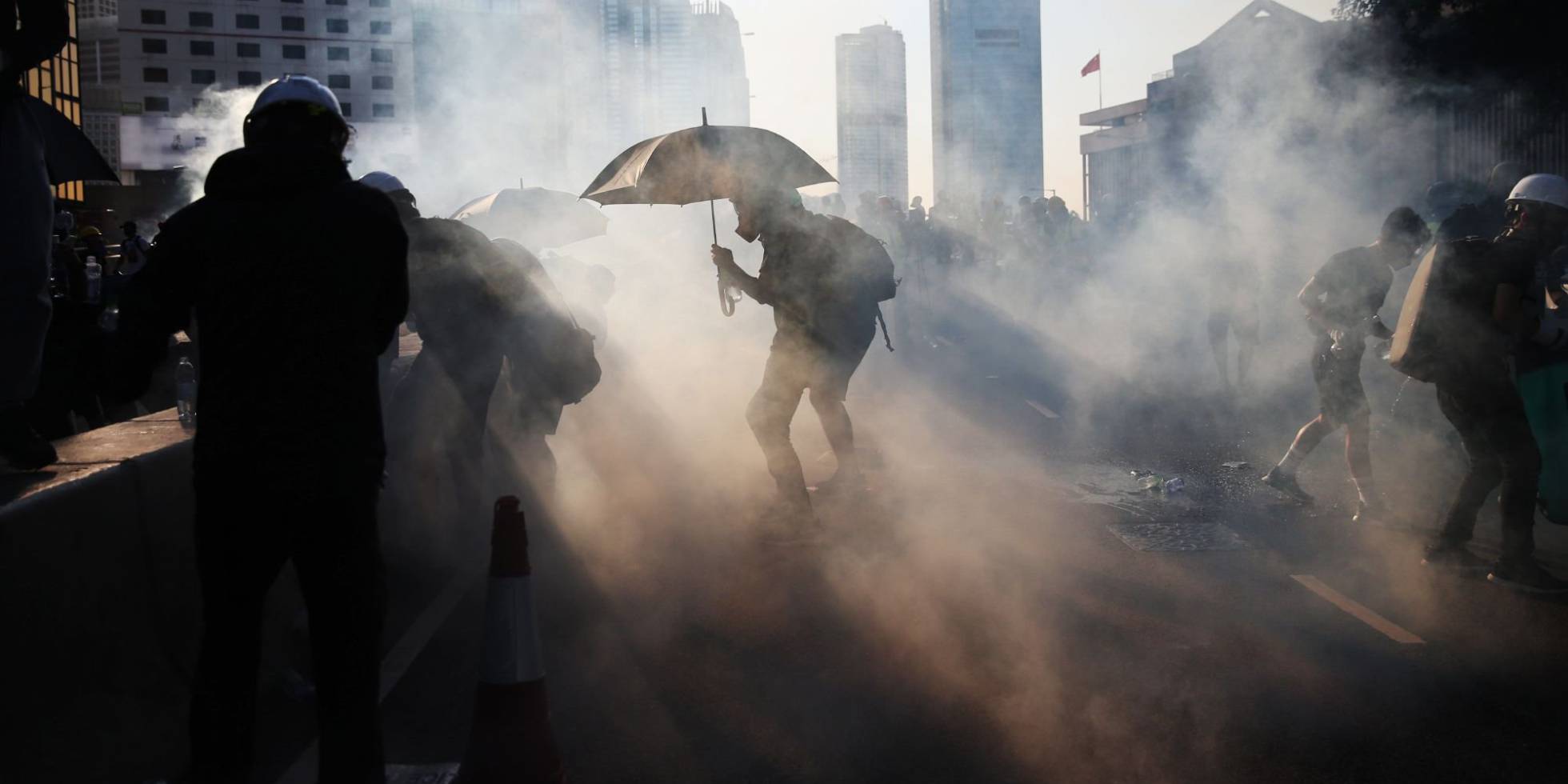 Un manifestante se protege con un paraguas de los gases lacrimógenos lanzados por la policía en Hong Kong.