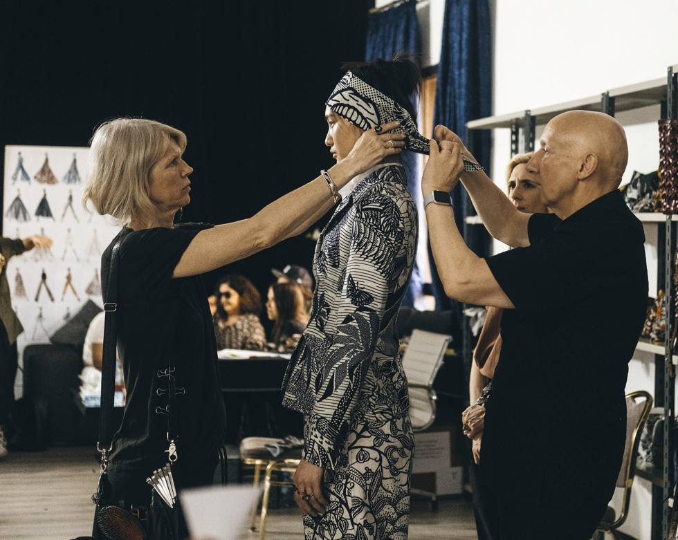 El sombrerero Stephen Jones coloca un turbante a una modelo.