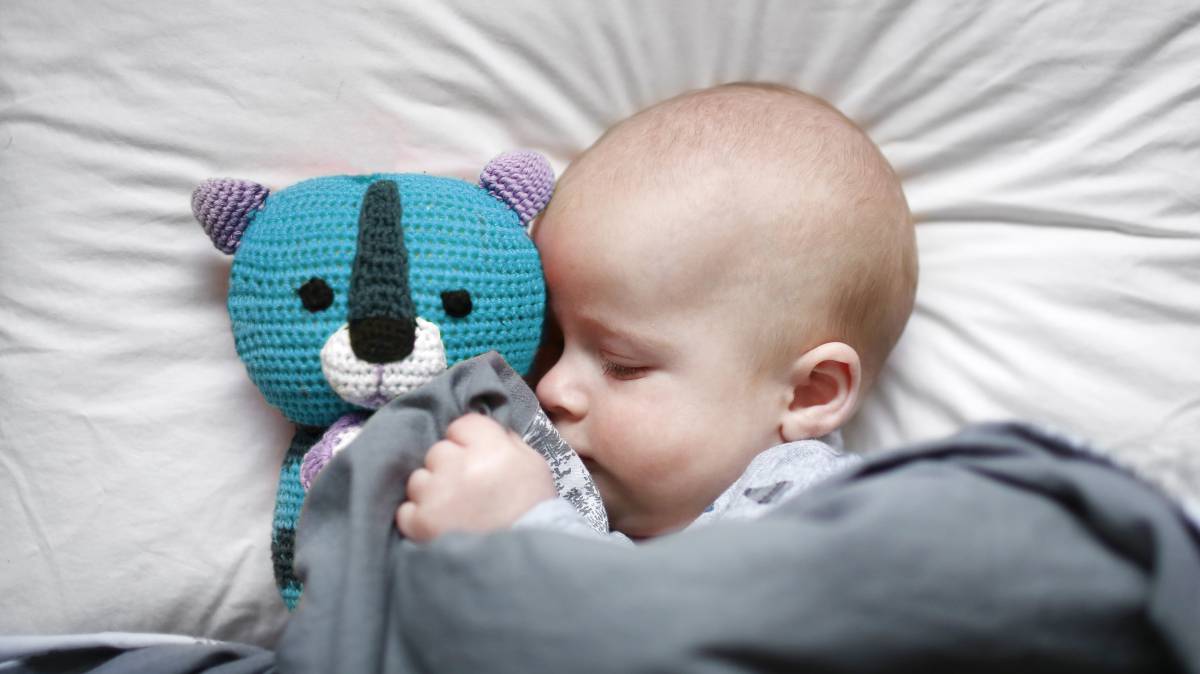 Un bebé dormido en su cuna.