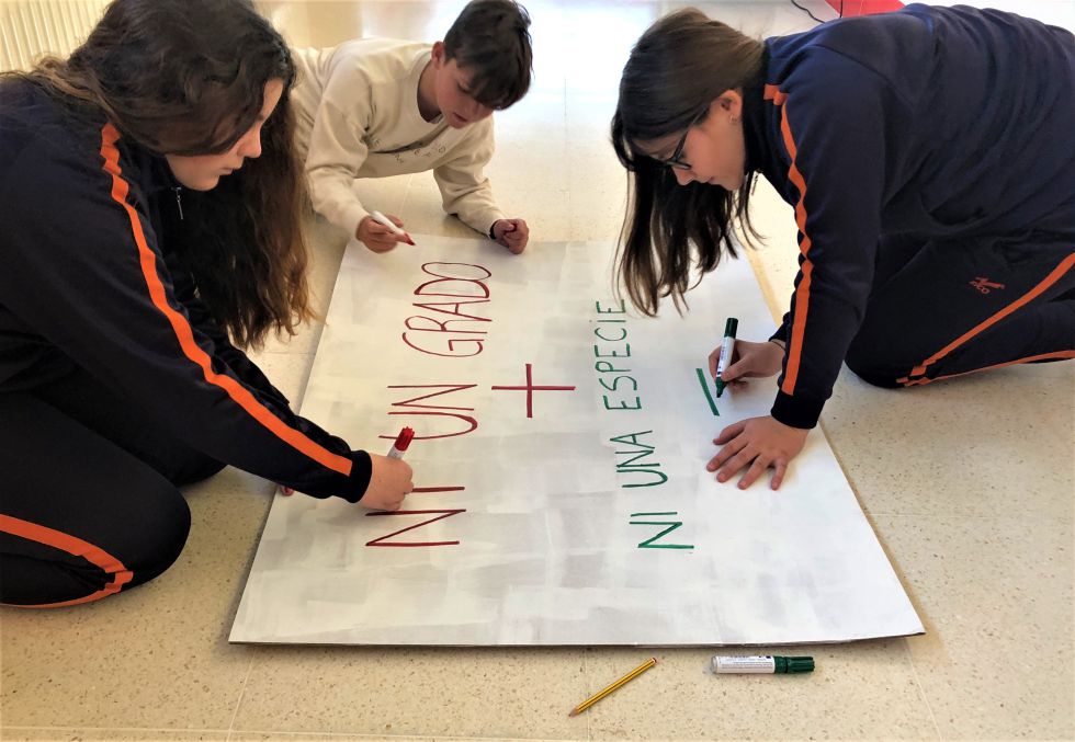 Estudiantes preparando una pancarta para la manifestación de