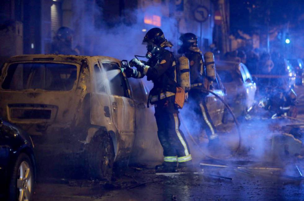 Firefighters put out fires set by protesters in Barcelona.