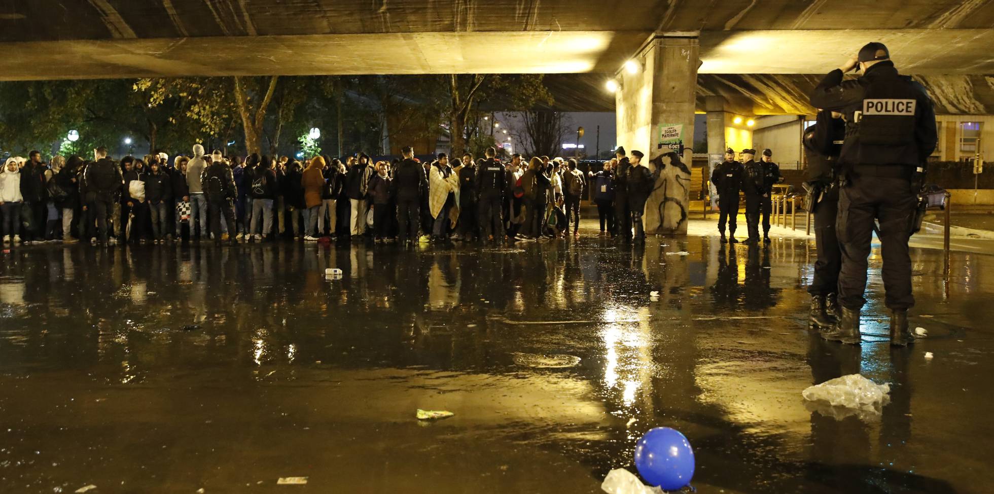 Los oficiales de policía vigilan a los migrantes mientras despejan un área eSTE jueves, en el norte de París.