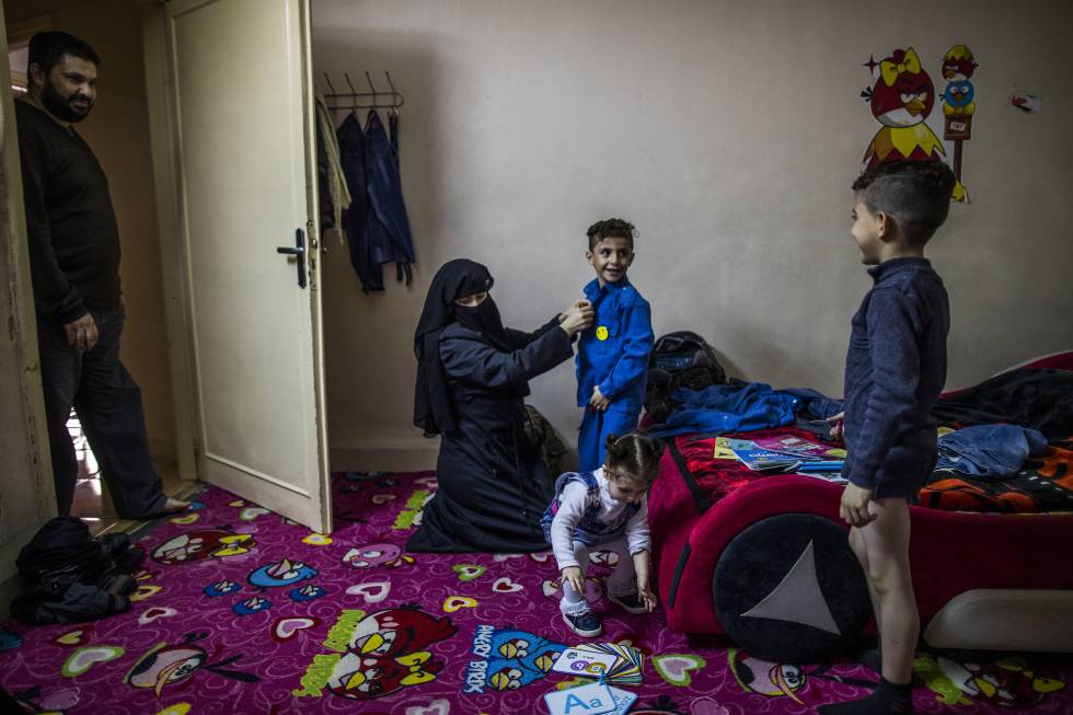 Hanan, la madre, ayuda a vestirse a los niños antes de ir a la escuela ante la atenta mirada del padre, Mohamed.