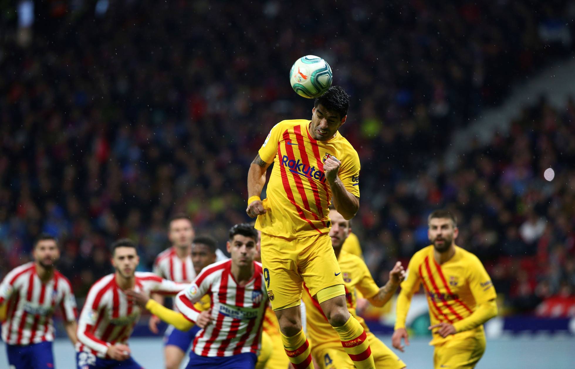 Luis Suárez cabecea un balón ante la defensa del Alético.