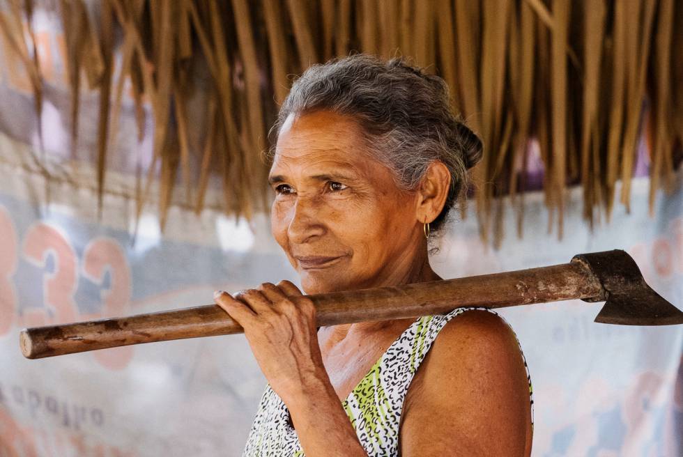 Doña Ivonete abre los cocos con un hacha de mango largo.