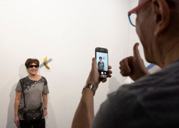 Una mujer se fotografía junto a la obra 'Comedian', el sábado.