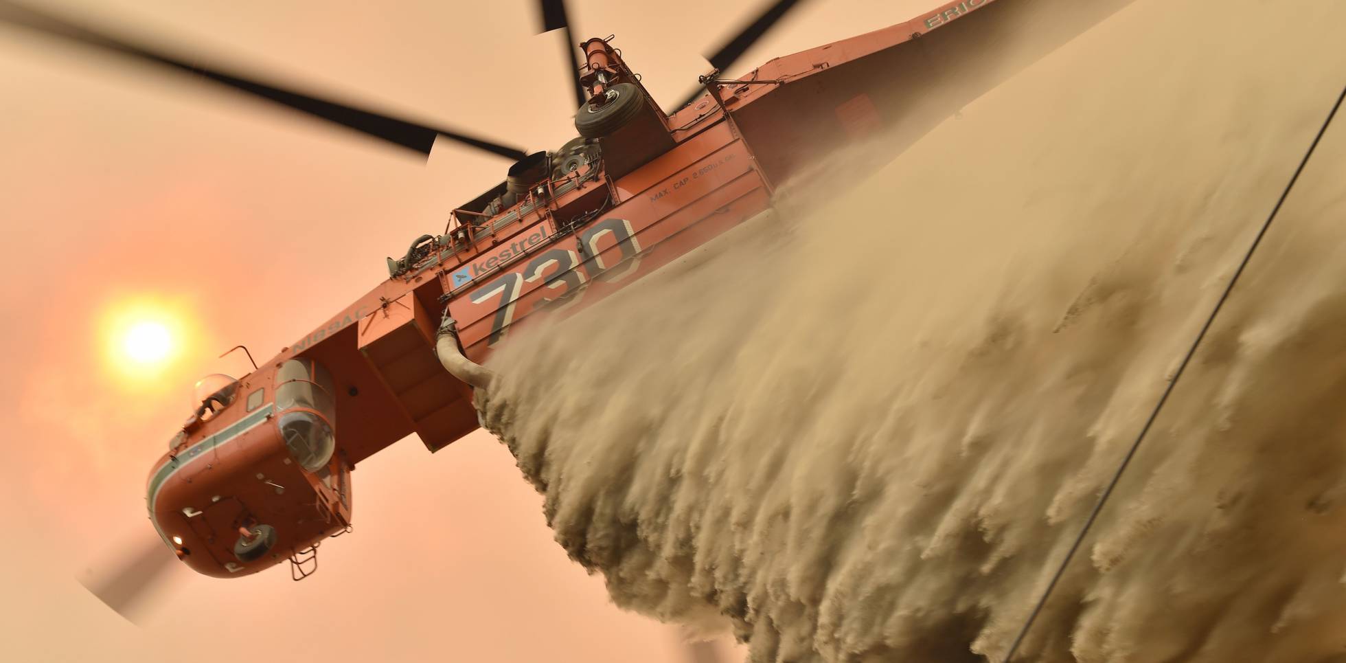 Un helicóptero arroja retardante de fuego para proteger una propiedad en Balmoral (Sydney).
